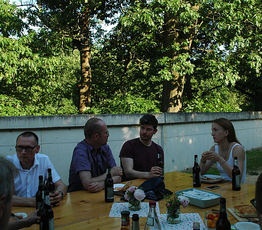 [Translate to Englisch:] 4 Personen sitzen am Tisch