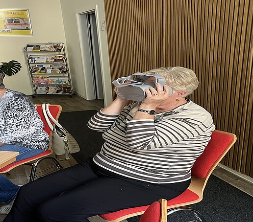 [Translate to Englisch:] Eine Dame probiert eine VR-Brille aus