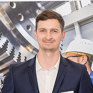 Manuel Isensee steht bei der Preisverleihung auf der Bühne und hält seinen symbolischen Scheck über 800 Euro.