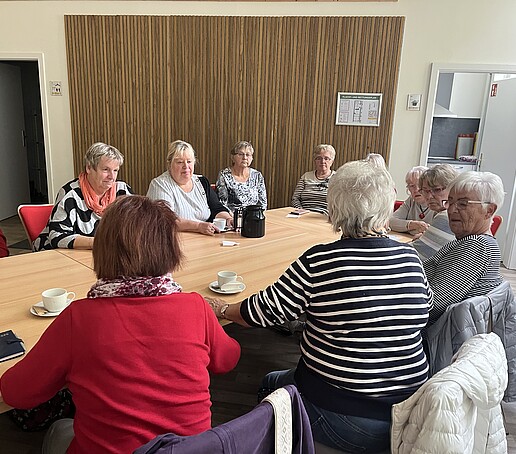 [Translate to Englisch:] Viele ältere Damen sitzen am Tisch und unterhalten sich