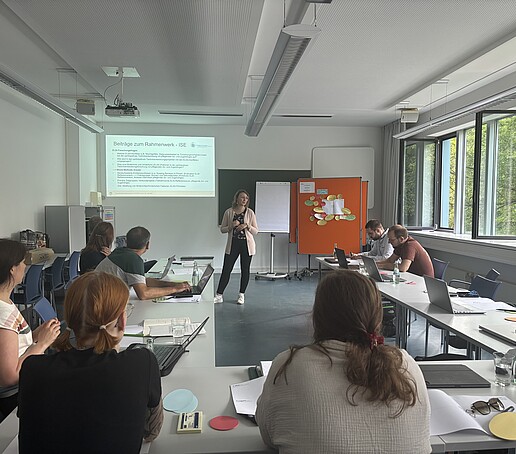 [Translate to Englisch:] Teilnehmer hören einer Referentin zu