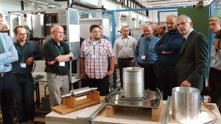 Prof. Ralf Werner (TU Chemnitz, 2nd from right) explaining experimental equipment during the lab tour