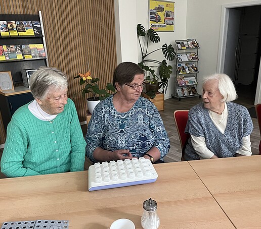 [Translate to Englisch:] 3 Damen begutachten eine Medikamentenbox