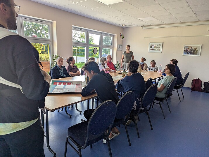 [Translate to Englisch:] Mehrere Teilnehmende in einem Besprechungsraum am Tisch sitzend