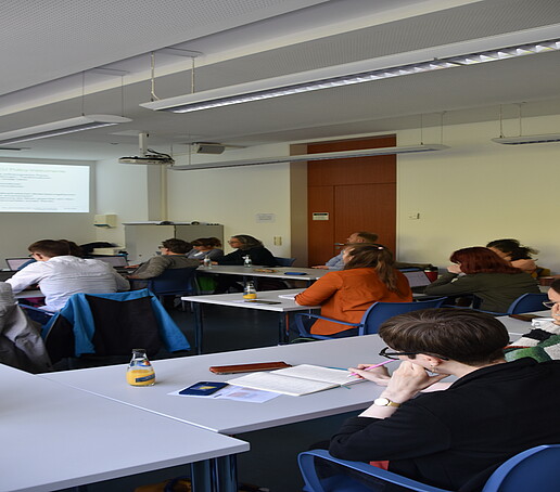 [Translate to Englisch:] Mehrere Zuhörer im Seminrraum von hinten