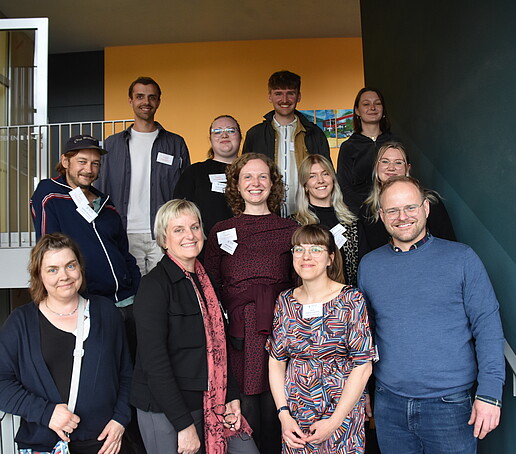 [Translate to Englisch:] Gruppe von Mitarbeitern posiert auf der Treppe