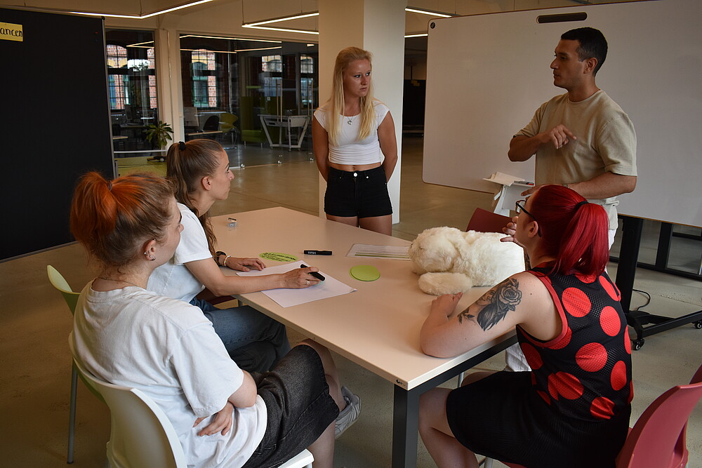 Participants sit around a table and discuss the potential of AI