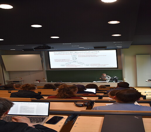 [Translate to Englisch:] Hörsaal von Hinten mit Blick auf die Projektionswand