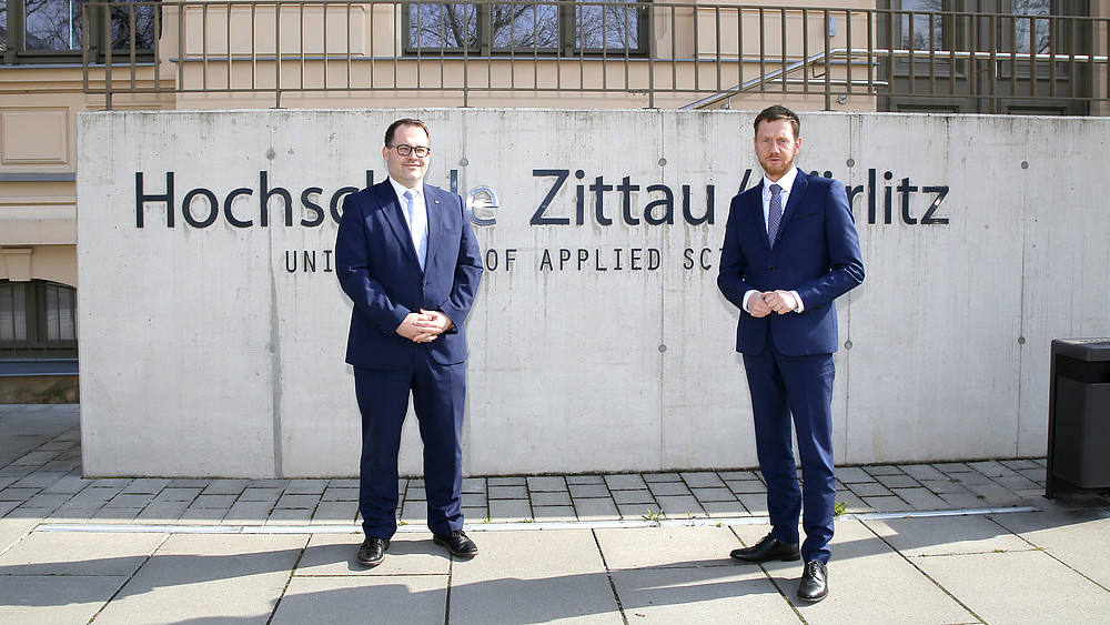 The Rector and Prime Minister stand in front of the HSZG sign in front of House Z I.
